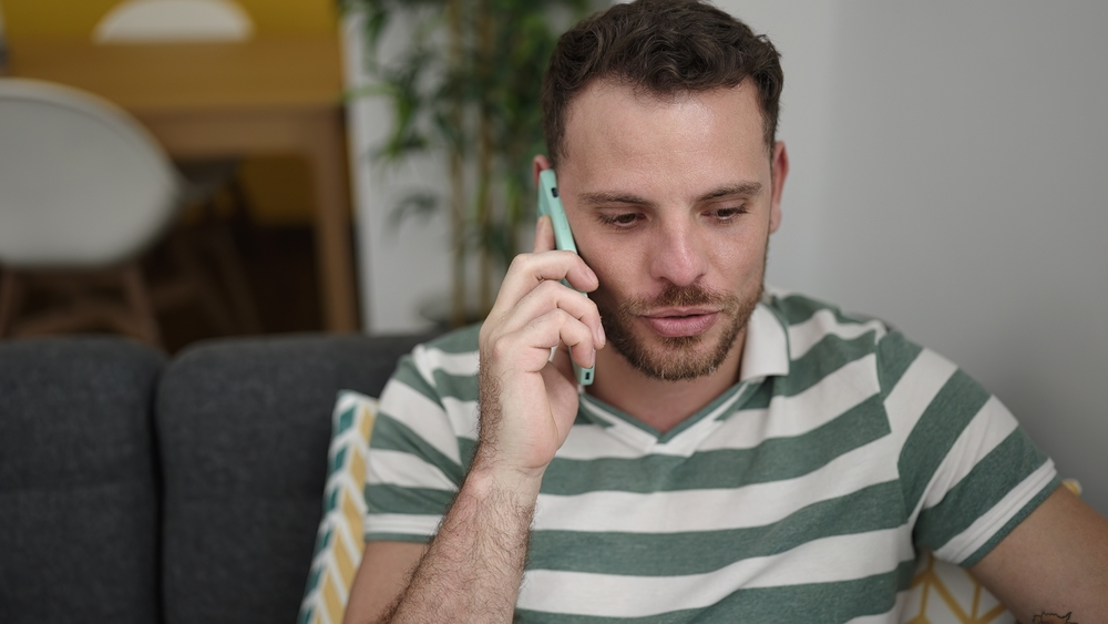 A man at home talking to an adviser on his phone